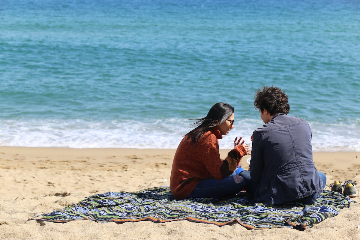 Man and Woman Sitting Near Beach